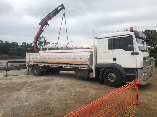 Crane truck loaded with timber packs for a Mackay building site delivery